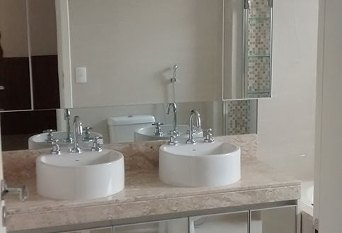banheiro branco com duas pias e espelho