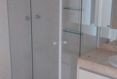 banheiro com espelho e box de canto