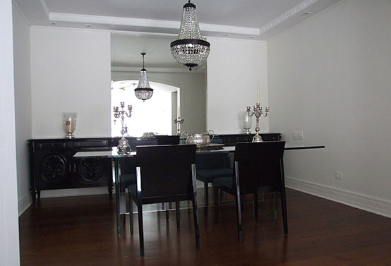sala de jantar com móveis coloniais, espelho e mesa de vidro