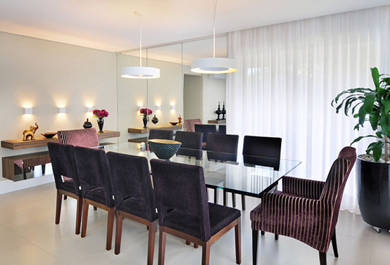 moderna sala de jantar com cortinas, espelho e mesa de vidro