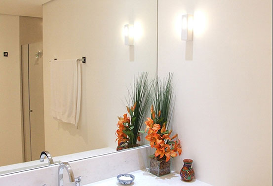 banheiro ou lavabo com espelho, pia branca e decoração floral