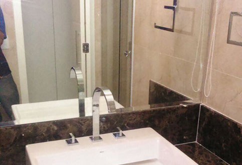 banheiro ou lavabo com espelho, pia com pedra marrom